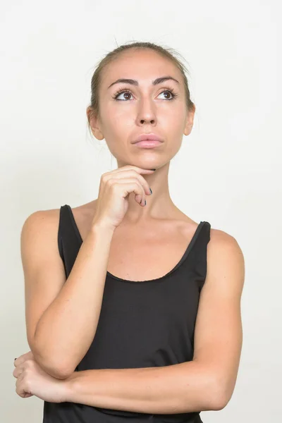 Young woman with brown hair thinking and looking up — Stock Photo, Image