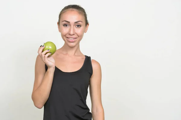 Portrét šťastné mladé ženy držící jablko připravené pro tělocvičnu — Stock fotografie