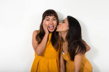 Studio shot of two young Asian women together against white background