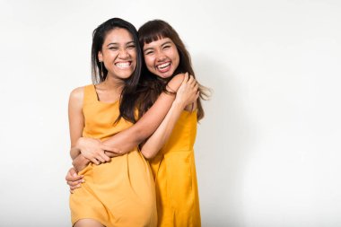 Studio shot of two young Asian women together against white background