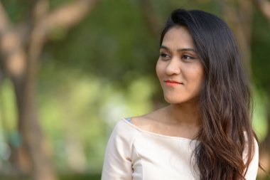 Portrait of Asian businesswoman relaxing at the park outdoors
