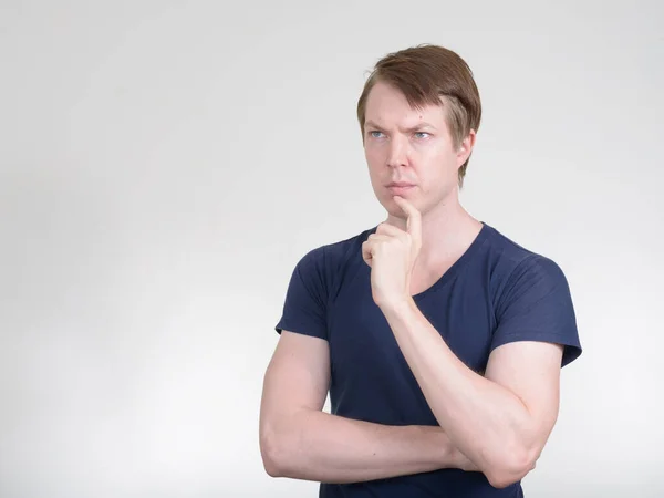 Retrato de un joven guapo pensando y mirando hacia arriba — Foto de Stock