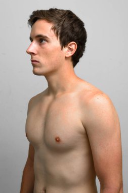 Studio shot of young handsome man shirtless against white background