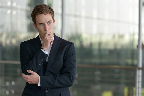 Portrait of young handsome businessman in suit at the airport outdoors