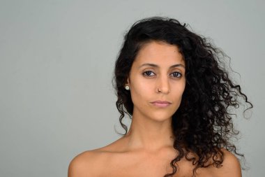 Kıvırcık saçlı, genç ve güzel İspanyol kadının stüdyo fotoğrafı.  
