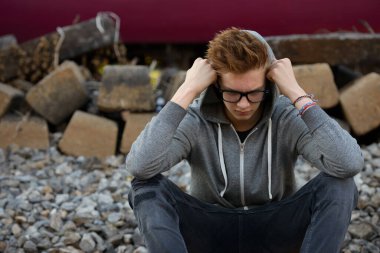 Portrait of young handsome teenage boy at the railway train station