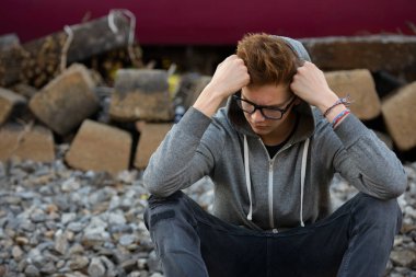 Portrait of young handsome teenage boy at the railway train station