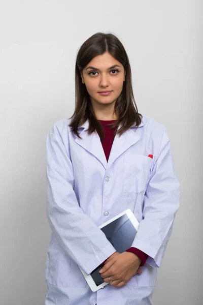 Studio shot of young beautiful woman doctor against white background