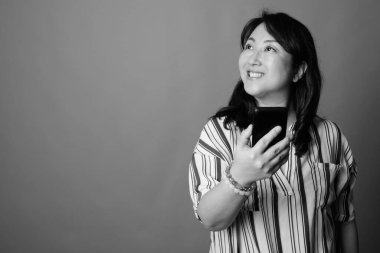 Yetişkin, güzel bir Japon kadının, siyah beyaz gri arka planda çekilmiş bir fotoğrafı.