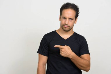 Studio shot of handsome bearded Hispanic man with curly hair against white background