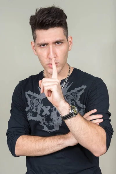Porträt eines gestressten jungen multiethnischen Mannes mit dem Finger auf den Lippen — Stockfoto