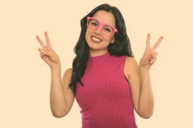 Studio shot of young beautiful Hispanic woman with wavy hair 
