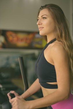 Spor salonunda çalışan güzel bir kadının portresi.