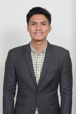 Studio shot of handsome Filipino businessman in suit against white background