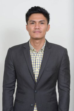 Studio shot of handsome Filipino businessman in suit against white background