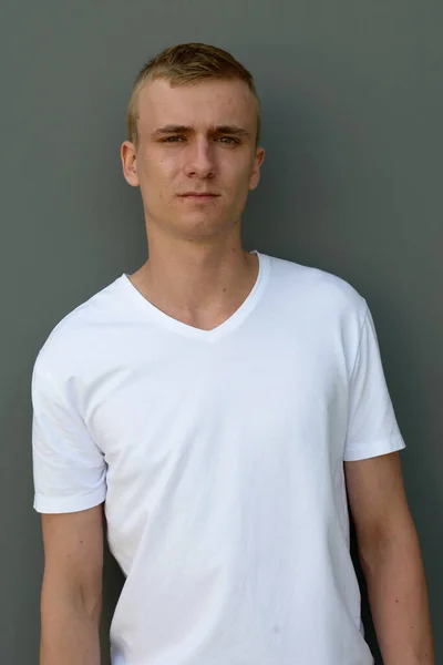 Portret Młodego Mężczyzny Blond Włosami Szarości Betonowa Ściana Zewnątrz — Zdjęcie stockowe