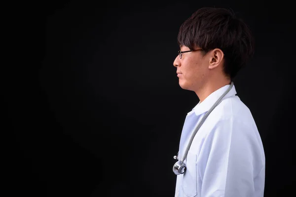 Studio Záběr Mladý Pohledný Asijské Člověk Lékař Proti Černé Pozadí — Stock fotografie