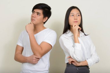 Genç, yakışıklı Filipinli bir adam ve güzel bir Asyalı kadının beyaz arka planda çekilmiş bir fotoğrafı.