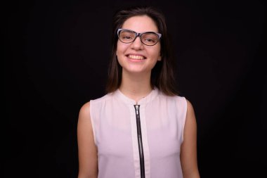 Siyah arka planda genç ve güzel bir iş kadınının stüdyo çekimi.
