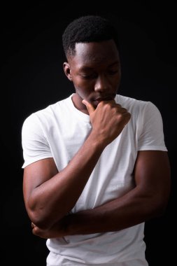 Siyah arka planda Afro saçlı yakışıklı Afrikalı genç adamın stüdyo fotoğrafı.