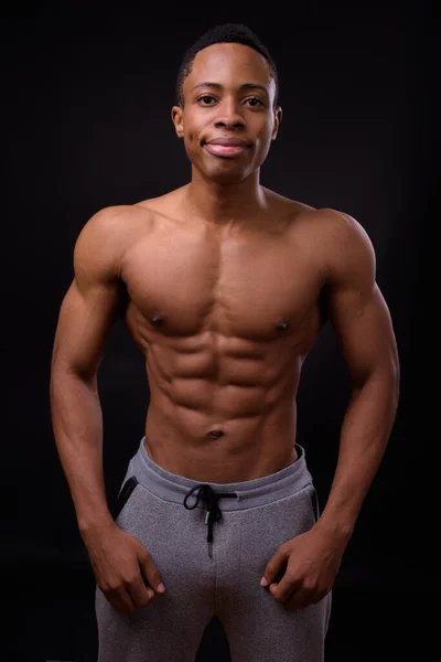 스튜디오에서 잘생긴 근육질의 아프리카 남자가 배경에 셔츠를 — 스톡 사진