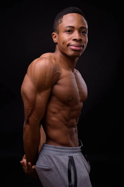 非洲年轻英俊 肌肉发达的男子在黑色背景下赤身裸体拍照 — 图库照片