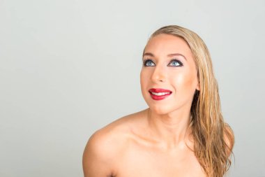 Gri arka planda sarışın güzel bir kadının stüdyo fotoğrafı.