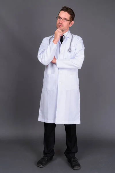 Gri Arka Planda Gözlüklü Yakışıklı Sakallı Doktorun Stüdyo Fotoğrafı — Stok fotoğraf