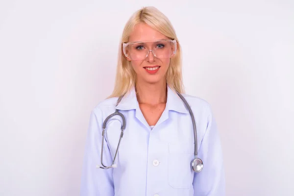 スタジオショットの若いです美しいですブロンド女性医師として科学者身に着けています保護メガネに対する白い背景 — ストック写真