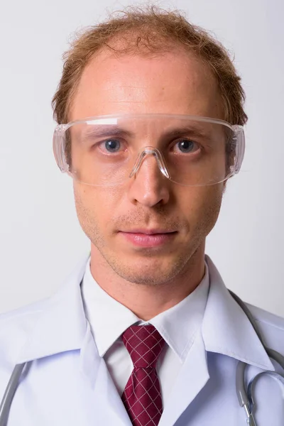 スタジオショットの男医師としてブロンド髪と科学者身に着けています保護眼鏡に白い背景 — ストック写真