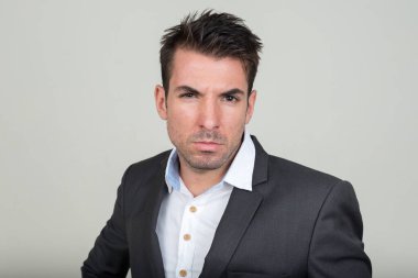 Beyaz arka plana karşı takım elbiseli yakışıklı İspanyol işadamının stüdyo fotoğrafı.