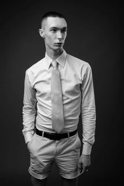 スタジオショットの若いですハンサムな男色のビジネスマンに対してグレーの背景で黒と白 — ストック写真