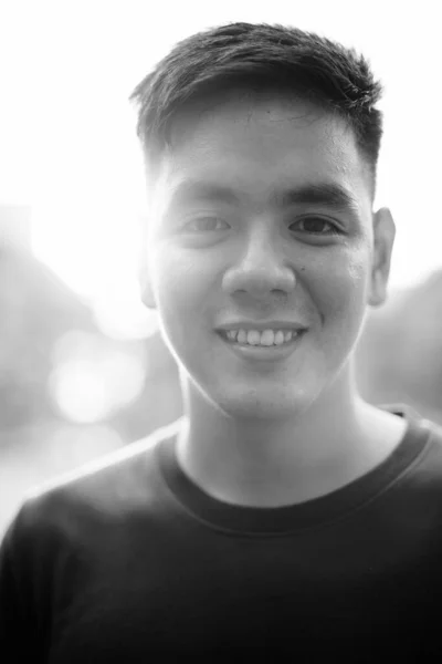 年轻英俊的菲律宾人穿着黑白相间的衣服在公园里放松的画像 — 图库照片