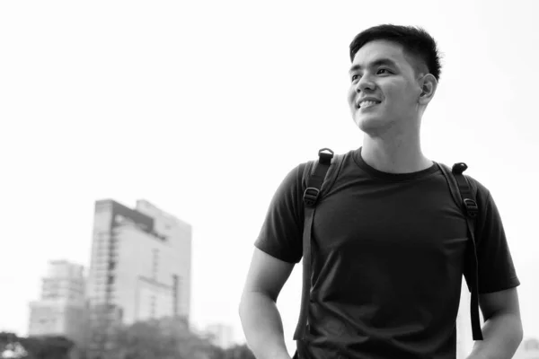 年轻英俊的菲律宾游客穿着黑色和白色背包在公园放松的画像 — 图库照片