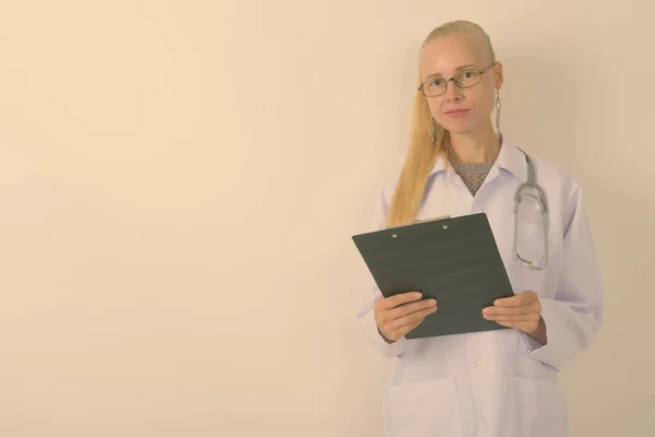 Estúdio Tiro Mulher Loira Bonita Médico Segurando Prancheta Contra Fundo — Fotografia de Stock