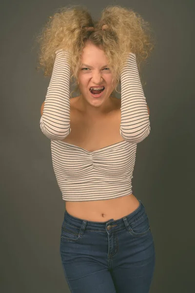Studio Strzał Młodej Pięknej Kobiety Blond Kręcone Włosy Szarym Tle — Zdjęcie stockowe