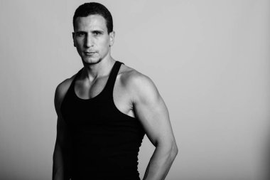 Siyah beyaz gri arka planda genç kaslı Pers erkeğinin stüdyo çekimi