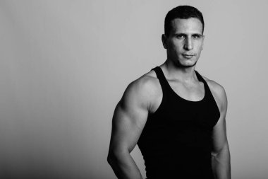 Siyah beyaz gri arka planda genç kaslı Pers erkeğinin stüdyo çekimi