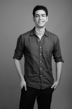 Siyah beyaz gri arka planda genç ve yakışıklı İranlı işadamının stüdyo çekimi