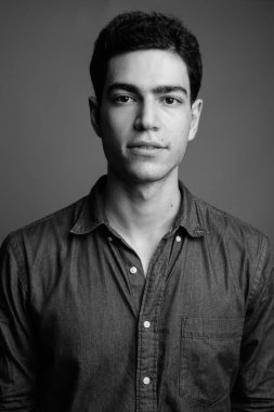 Siyah beyaz gri arka planda genç ve yakışıklı İranlı işadamının stüdyo çekimi