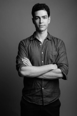 Siyah beyaz gri arka planda genç ve yakışıklı İranlı işadamının stüdyo çekimi