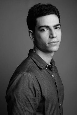 Siyah beyaz gri arka planda genç ve yakışıklı İranlı işadamının stüdyo çekimi