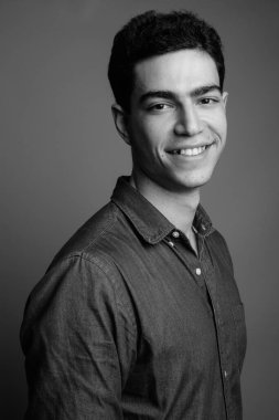 Siyah beyaz gri arka planda genç ve yakışıklı İranlı işadamının stüdyo çekimi