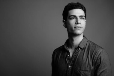 Siyah beyaz gri arka planda genç ve yakışıklı İranlı işadamının stüdyo çekimi