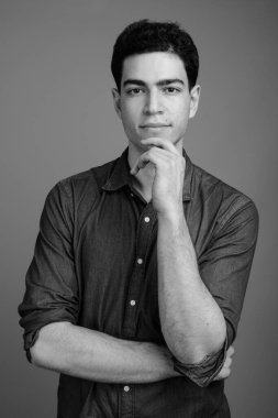 Siyah beyaz gri arka planda genç ve yakışıklı İranlı işadamının stüdyo çekimi