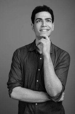 Siyah beyaz gri arka planda genç ve yakışıklı İranlı işadamının stüdyo çekimi