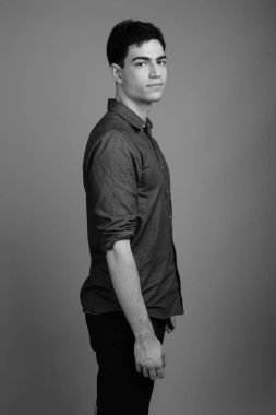 Siyah beyaz gri arka planda genç ve yakışıklı İranlı işadamının stüdyo çekimi