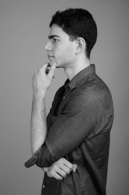 Siyah beyaz gri arka planda genç ve yakışıklı İranlı işadamının stüdyo çekimi