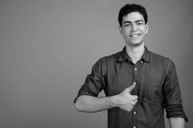 Siyah beyaz gri arka planda genç ve yakışıklı İranlı işadamının stüdyo çekimi