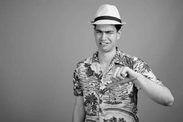 演播室拍摄年轻英俊的波斯游客身穿夏威夷衬衫 头戴一顶帽子 准备穿黑白相间的衣服度假 — 图库照片